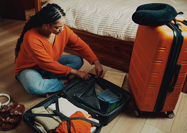istock Woman Packing Clothes in a Suitcase 2210456898