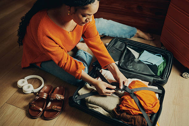 istock Woman Packing Clothes in a Suitcase 2210456909