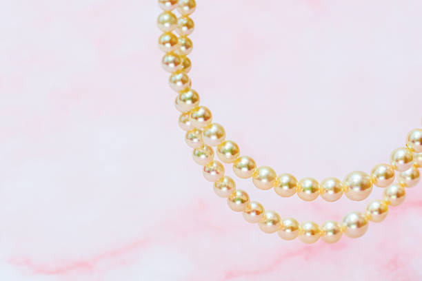 istock Pearl necklace isolated on a pink marble pattern background. 2210457744