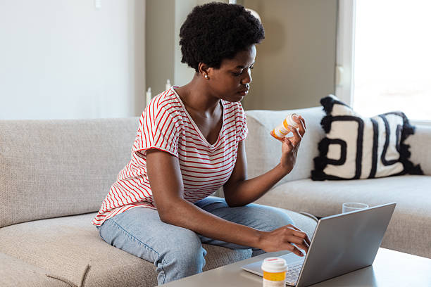 istock Woman researching and taking medication at home using a laptop 2210457821