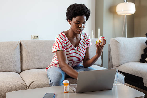 istock Woman checking medication instructions online using laptop at home on a sofa 2210457840