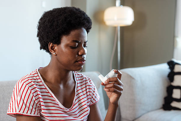 istock Woman sitting indoors using an inhaler for respiratory relief 2210457882
