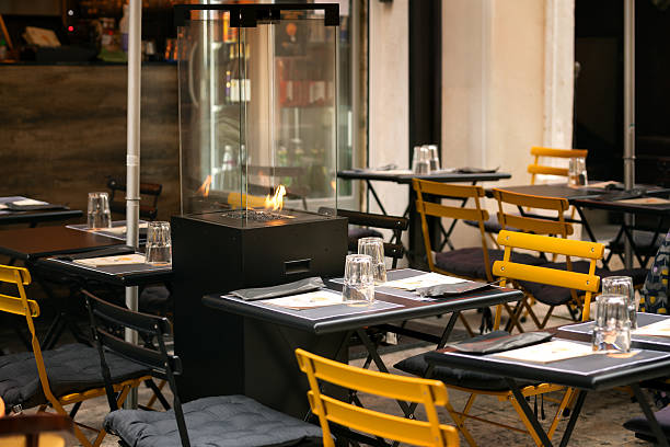 istock An open-air restaurant with set tables and a modern glass fireplace. 2210459073