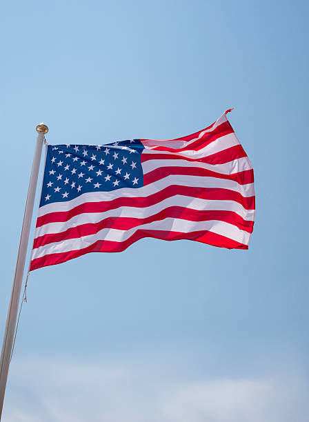 istock US flag proudly waving in the wind on flagpole 2210460567