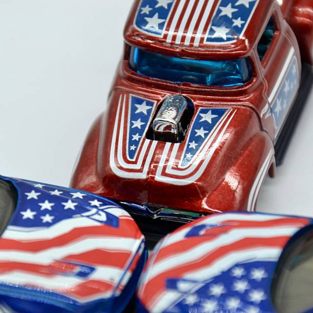 istock Closeup studio shot on white background is a concept for US or American auto industry with toys cars and truck with Stars and Stripes decals in the side and hood 2210461833