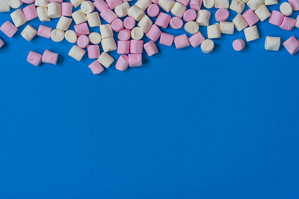 istock Mini white and pink marshmallows on blue background. 2210464499