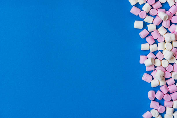 istock Mini white and pink marshmallows on blue background. 2210464508