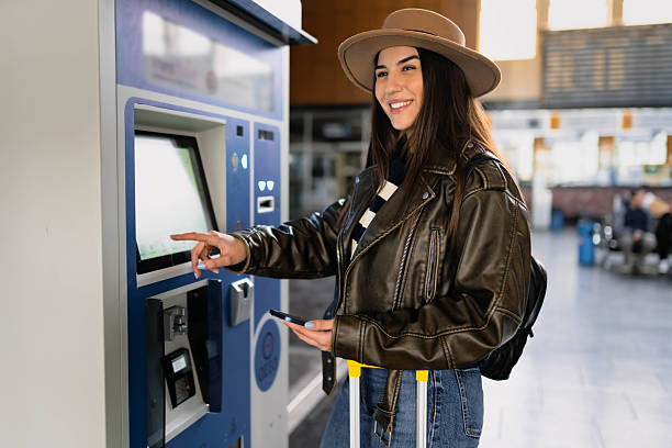 istock A woman buys a train ticket at a ticket machine. 2210469577