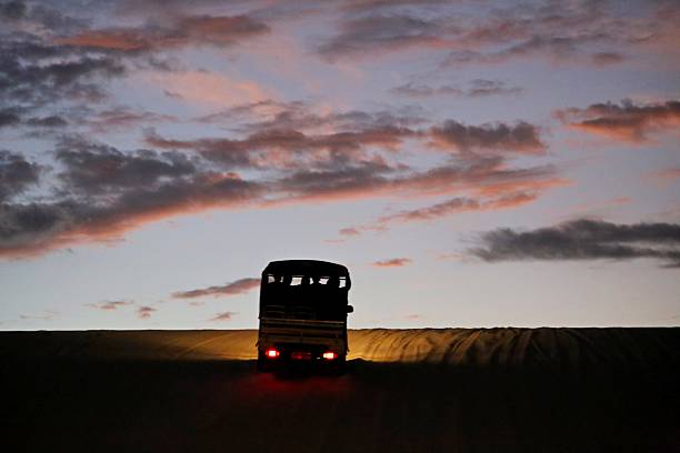 Off road vehicle over Lencois Maranhenses sand dunes. Lights on, sky over horizon line