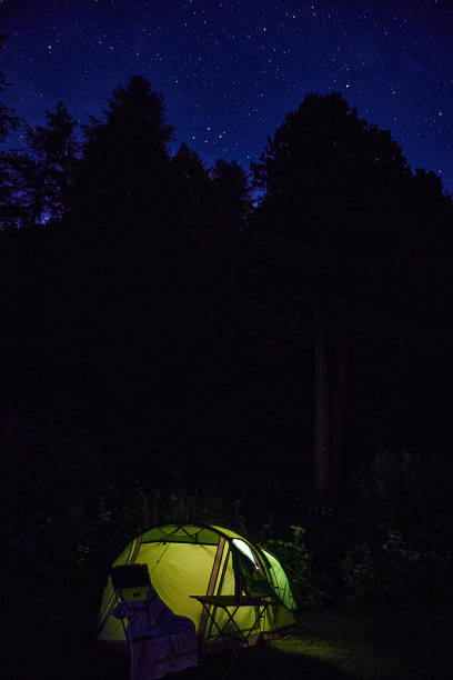 istock Camping Tent Illuminated at Night Under a Starry Sky in the Woods 2210471884
