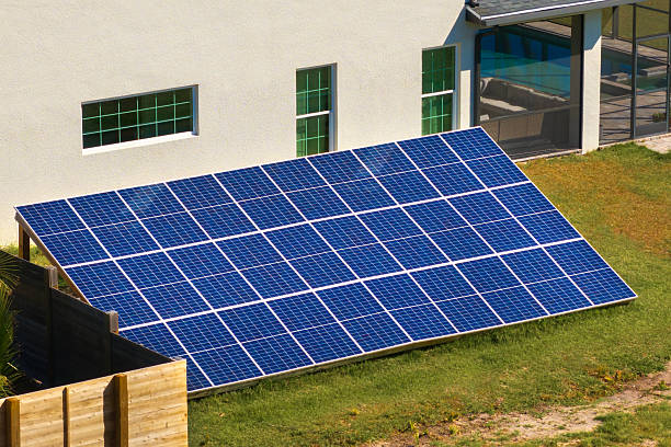 istock Private home with solar photovoltaic panels mounted on stand-alone frame on backyard ground for generating of clean ecological electric energy in suburban rural town area. Concept of autonomous house 2210471997