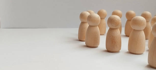 istock Group of wooden figures representing community interaction minimalist studio setting still life neutral background 2210473816