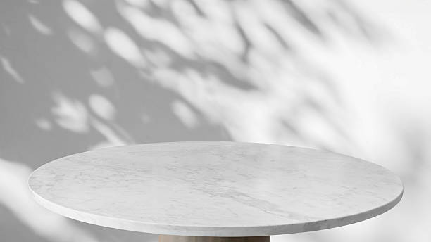 istock Round marble table top with tree leaves shadow drop on white wall background for mockup product display 2210476253