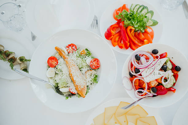 Colorful salads and seafood are beautifully arranged on a table for a gathering.
