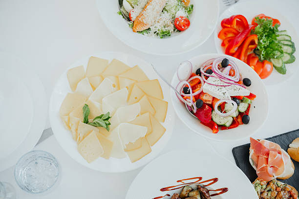 A vibrant selection of salads, cheeses, and fresh vegetables laid out on a table.