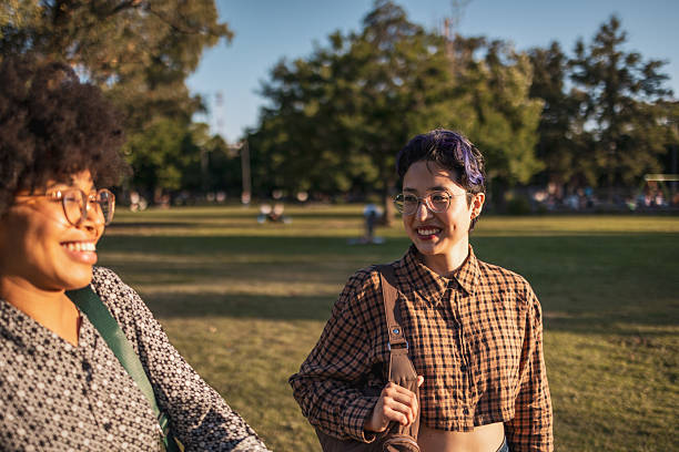 Two friends sharing a joyful moment in a scenic park setting