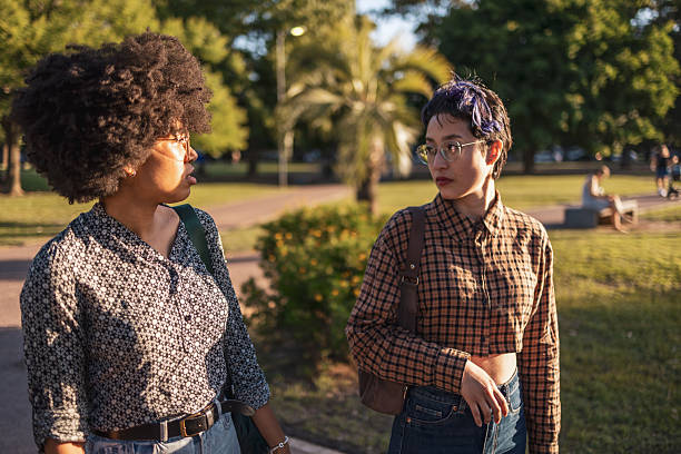 istock Two friends having a conversation in a sunny park setting 2210477591
