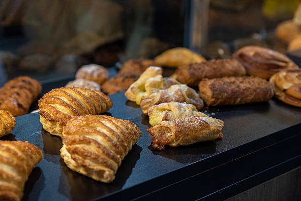 istock Various puff pastries with sugar crust in a bakery window 2210484752