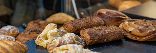 istock Various puff pastries with sugar crust in a bakery window 2210484755