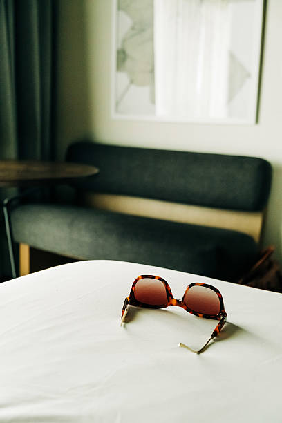 istock Stylish sunglasses resting on a hotel bed in a cozy room 2210487734