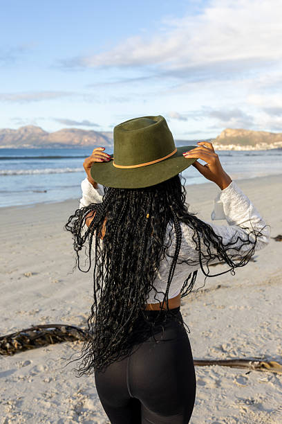 istock Young woman with hat on walking on the beach 2210487818
