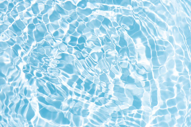 istock Blue water with ripples on the surface. Defocus blurred transparent blue colored clear calm water surface texture with splashes and bubbles. Water waves with shining pattern texture background. 2210489409