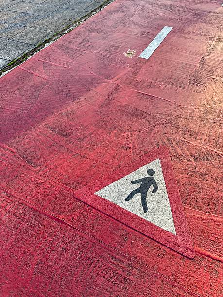 istock Pedestrian crossing sign painted on red asphalt road surface 2210492582