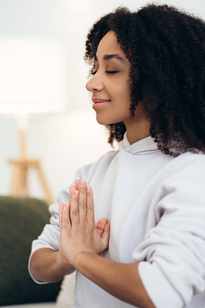 istock Young woman practicing yoga and meditating at home 2210495380