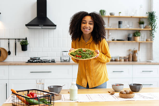 istock Young woman holding fresh salad in kitchen 2210495385