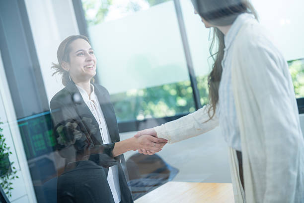 istock Business professionals engage in handshake during meeting in modern office demonstrating collaboration and networking 2210496452