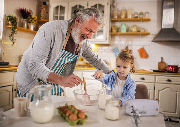istock Grandpa helping grandson cook pancakes for breakfast 2210499880