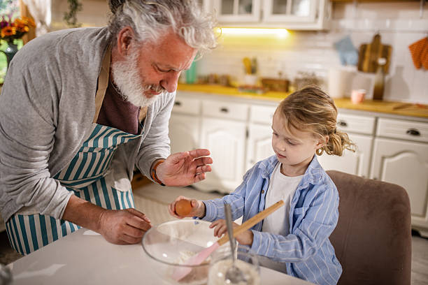 istock Grandpa helping grandson cook pancakes for breakfast 2210499881