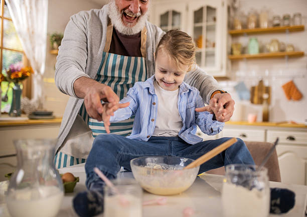 istock Grandpa helping grandson cook pancakes for breakfast 2210499984