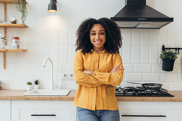 istock Confident woman smiling with arms crossed in modern kitchen 2210501939
