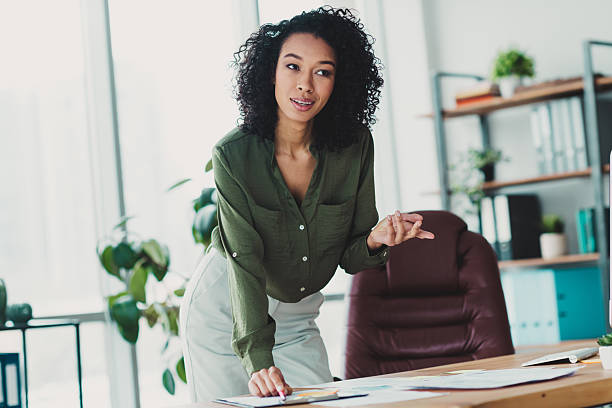 istock Confident young businesswoman working in a bright and modern office setting, engaging in thoughtful collaboration 2210507846