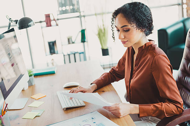 istock Businesswoman working at a modern office on professional tasks, reviewing documents and computer work in a stylish and bright workspace 2210508302
