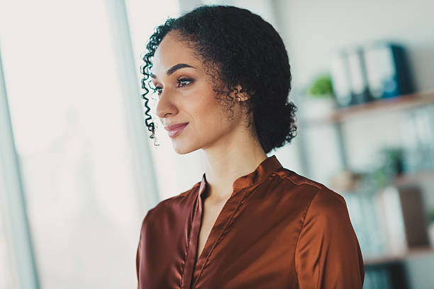 istock Confident young black businesswoman working in a modern office environment, posing thoughtfully by a brightly lit window 2210508356