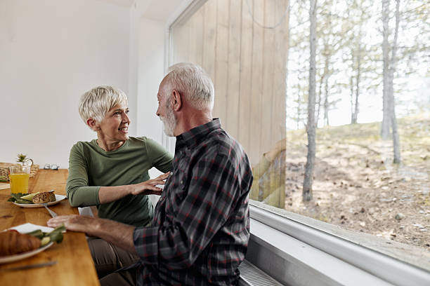istock Happy mature couple talking during breakfast at dining table. 2210510093