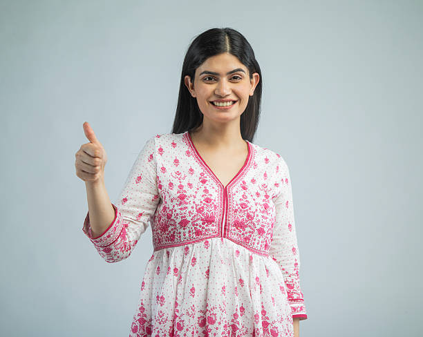 istock Woman gesturing thumbs up on white background 2210510148
