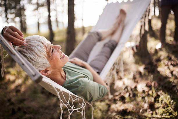istock Relaxed mature woman enjoying during spring day in hammock. 2210510272