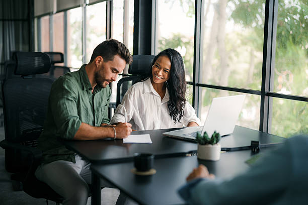 istock Multiracial colleagues discussing startup project and smiling during workday in office interior 2210510508