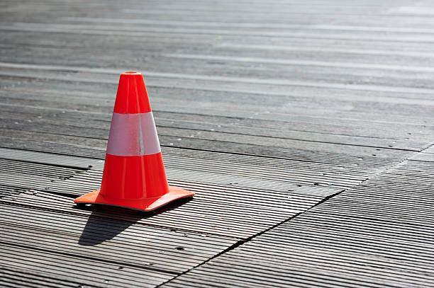 istock Orange traffic cone sitting on a wooden floor 2210511185
