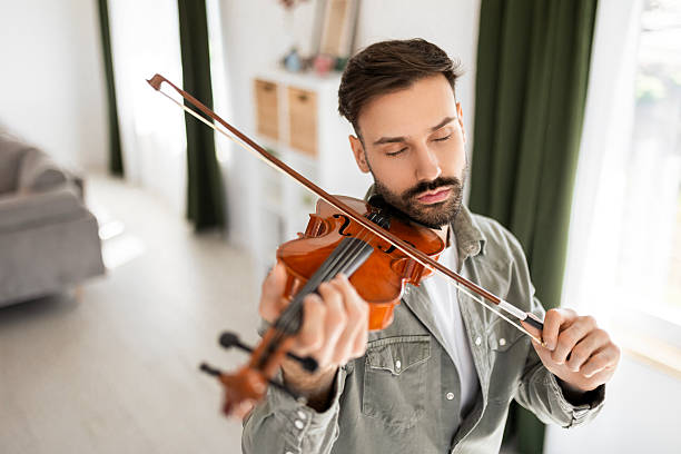 istock Man playing violin at home 2210511605
