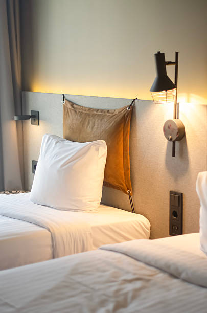 istock Cozy modern hotel room with clean white beds and warm lighting 2210512428