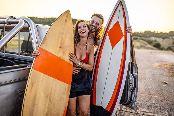 istock Surfer couple having fun by the car at sunset 2210512931