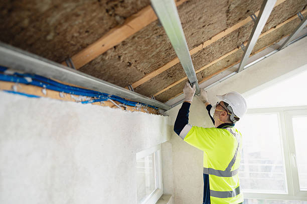 istock Construction worker insulating attic roof with metal frame and mineral wool 2210517889