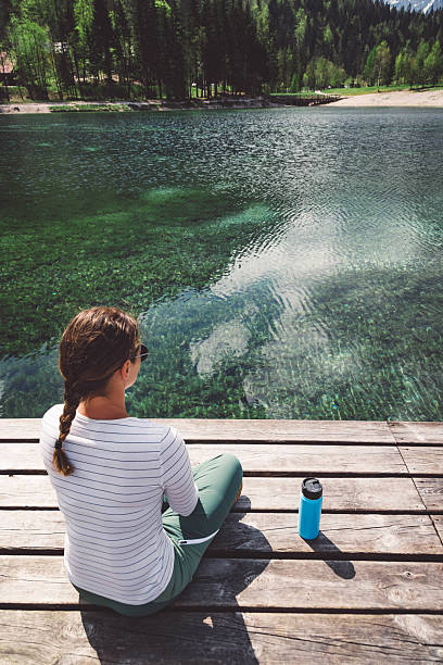 istock Woman Relaxing by a Clear Lake 2210517950