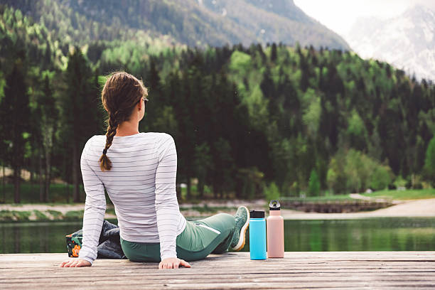 istock Woman Relaxing by the Lake on a Dock 2210517953