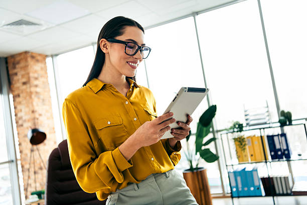 istock Professional businesswoman using a tablet in a modern office environment with natural daylight and contemporary decor 2210518359