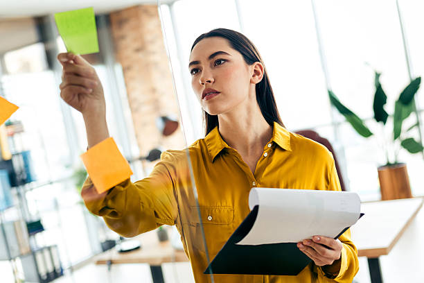 istock Professional businesswoman brainstorms ideas with sticky notes in a modern office workspace 2210518401